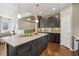 Open kitchen with dark wood cabinets, an island, and modern lighting at 5876 Alton St, Denver, CO 80238