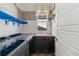 Well-lit laundry room with a sink, dark cabinets, and a window at 5876 Alton St, Denver, CO 80238