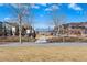 Wide shot of neighborhood street with lush grass and trees on a sunny day at 5876 Alton St, Denver, CO 80238