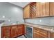 Basement wet bar with wood cabinets and tile countertops at 9535 S Shadow Hill Cir, Lone Tree, CO 80124