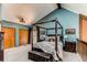 Comfortable bedroom with a four-poster bed, vaulted ceiling, and rustic decor at 25257 Snyder Ave, Conifer, CO 80433