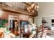 Dining area with vaulted ceilings, exposed brick, decorative chandelier, and a view of the kitchen at 25257 Snyder Ave, Conifer, CO 80433
