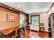 Open concept dining area with brick wall, wood floors, large window, and view of green landscape at 25257 Snyder Ave, Conifer, CO 80433