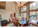 Dining area with hardwood floors, decorative chandelier, and multiple large windows with an outdoor deck view at 25257 Snyder Ave, Conifer, CO 80433