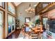 Dining area features vaulted ceilings, decorative chandelier, and large windows with an outdoor deck view at 25257 Snyder Ave, Conifer, CO 80433