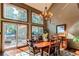 Dining area with hardwood floors, decorative chandelier, and multiple large windows with a deck view at 25257 Snyder Ave, Conifer, CO 80433