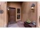 Covered front entry featuring paneled walls, lantern sconces, and a decorative door with side window at 25257 Snyder Ave, Conifer, CO 80433