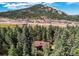 Home nestled among the trees, showcasing its wooded surrounding and natural beauty at 25257 Snyder Ave, Conifer, CO 80433