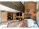 Inviting living room with a brick fireplace, wood-paneled walls, large windows and comfortable seating at 25257 Snyder Ave, Conifer, CO 80433