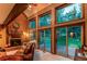 Charming living room with a brick fireplace and scenic views through large windows at 25257 Snyder Ave, Conifer, CO 80433