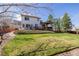 Expansive backyard with lush lawn, mature trees, and a charming covered deck for outdoor enjoyment at 9640 S Johnson St, Littleton, CO 80127