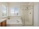 Bright bathroom with a soaking tub, glass shower, and tiled surround at 9640 S Johnson St, Littleton, CO 80127
