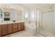 Large primary bathroom with double sinks, shower, soaking tub, and bright window at 9640 S Johnson St, Littleton, CO 80127
