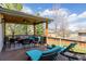 Spacious covered deck with a ceiling fan, plush seating, and lounge chairs overlooking the yard at 9640 S Johnson St, Littleton, CO 80127