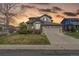 Charming two-story home with a well-manicured lawn and attached two-car garage at sunset at 9640 S Johnson St, Littleton, CO 80127
