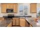 Galley kitchen boasts granite countertops, stainless steel appliances, and wood cabinets at 9640 S Johnson St, Littleton, CO 80127