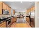 Well-equipped kitchen with stainless appliances, wooden cabinets, and a granite countertop island at 9640 S Johnson St, Littleton, CO 80127