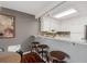 Well-lit kitchen featuring white cabinets, sleek countertops, and a convenient breakfast bar at 2891 W Long Dr # D, Littleton, CO 80120