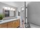 Clean bathroom with light wood cabinets and a view into another room at 3656 S Depew St # 104, Denver, CO 80235