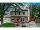 Charming two-story home with a red brick facade, manicured lawn, and lush landscaping at 312 Allen St, Golden, CO 80401