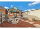 Inviting backyard with a stone fire pit, landscaping, and a charming brick home at 756 Kalamath St, Denver, CO 80204