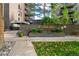Community entrance with manicured landscaping, brick facade, and covered entry at The Park Lane Condominiums at 460 S Marion Pkwy # 453, Denver, CO 80209