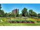 Exterior view showcasing beautifully landscaped gardens, a well-maintained lawn, and surrounding trees at 460 S Marion Pkwy # 453, Denver, CO 80209