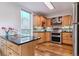 Kitchen with wooden cabinetry, granite countertops, stainless steel appliances, and hardwood floors at 460 S Marion Pkwy # 453, Denver, CO 80209