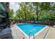 Outdoor pool area with blue water, lounge chairs, mature trees, and poolside privacy at 460 S Marion Pkwy # 453, Denver, CO 80209