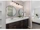 Modern bathroom boasts double sinks, sleek round mirrors, and a shower with glass doors at 9227 Englemann Ct, Parker, CO 80134