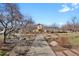 View of the building's exterior and yard, featuring trees, benches, and other landscape elements at 3223 Iron Forge Pl # 108, Boulder, CO 80301