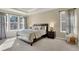 Calm bedroom with neutral colors, large windows, tray ceiling, and comfortable carpet at 9772 Taylor River Cir, Littleton, CO 80125