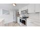Bright kitchen featuring stainless steel appliances, white countertops, and modern white cabinetry at 2330 Redwood Ave, Lafayette, CO 80026