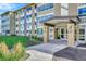 Apartment building entrance with awning, greenery and well-maintained lawn at 9655 E Center Ave # 9D, Denver, CO 80247