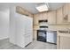 Bright kitchen features wood cabinets, a white refrigerator, and stainless steel dishwasher at 9655 E Center Ave # 9D, Denver, CO 80247