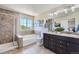 Bathroom with double vanity, soaking tub, glass-enclosed shower, and stylish tile work at 25097 E Lake Dr, Aurora, CO 80016