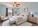 Comfortable bedroom featuring light blue walls, ceiling fan, neutral furnishings and large window for natural light at 25097 E Lake Dr, Aurora, CO 80016