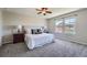 Cozy bedroom featuring a plush bed, neutral decor, and ample natural light from a large window at 25097 E Lake Dr, Aurora, CO 80016