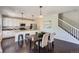 Dining room with dark wood floors open to the kitchen, featuring a stylish table with seating for four at 25097 E Lake Dr, Aurora, CO 80016