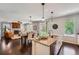 Open-concept kitchen featuring granite countertops, modern lighting, and dark wood floors flowing into the living space at 25097 E Lake Dr, Aurora, CO 80016