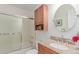 Bathroom featuring granite countertops, a bathtub with a sliding door, and a round mirror at 1005 S Miller Way, Lakewood, CO 80226