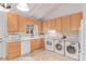 Bright kitchen with white appliances, wooden cabinets, and washer/dryer combo at 1005 S Miller Way, Lakewood, CO 80226