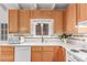 Well-lit kitchen featuring wood cabinets, white counters, and a multi-tone backsplash at 1005 S Miller Way, Lakewood, CO 80226