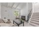 Inviting living room featuring a white brick fireplace, neutral tones, and staircase with iron railings at 1005 S Miller Way, Lakewood, CO 80226
