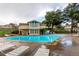 Community swimming pool with lounge chairs and a view of the clubhouse and surrounding trees at 1005 S Miller Way, Lakewood, CO 80226