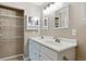 Bathroom featuring double sinks, large mirror, walk-in shower, and tiled walls at 703 S Depew St, Lakewood, CO 80226