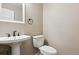 Modern bathroom with pedestal sink, toilet, and neutral color scheme at 703 S Depew St, Lakewood, CO 80226