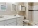 Bathroom featuring double sinks, large mirror, walk-in shower, and tiled walls at 703 S Depew St, Lakewood, CO 80226