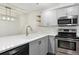 Well-lit kitchen features stainless steel appliances, gray cabinetry, and bright countertop at 703 S Depew St, Lakewood, CO 80226