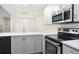 Well-lit kitchen features stainless steel appliances, gray cabinetry, and bright countertop at 703 S Depew St, Lakewood, CO 80226